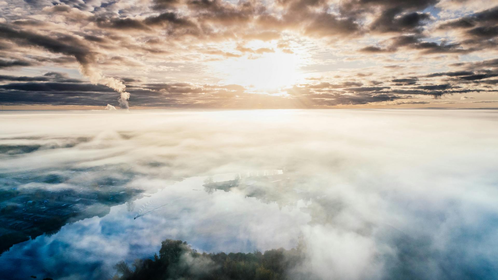 Photo of the sun shining above the clouds